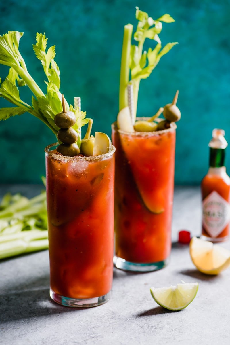 Bloody Maria cocktails garnished with olives, celery sticks, pickles, and pepperoncini peppers.