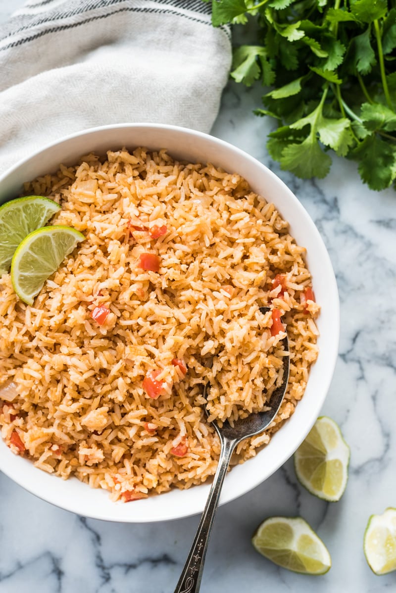 Mexican rice in a bowl with lime wedges