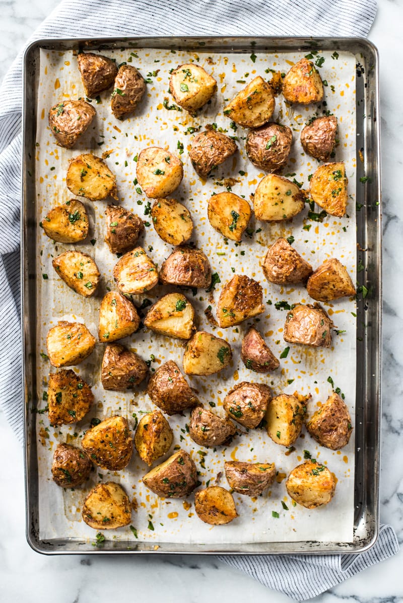 A large baking sheet filled with Mexican potatoes that have been baked and are crispy.