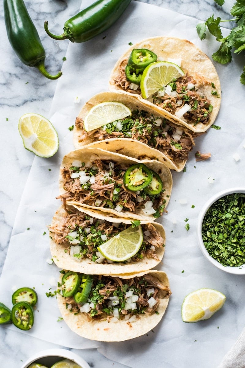 Juicy pork carnitas in warm corn tortillas topped with cilantro, onions and limes.