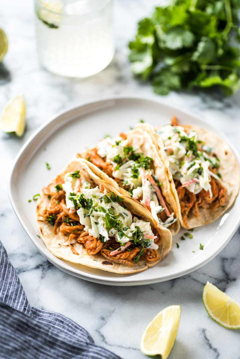 These Slow Cooker BBQ Pulled Pork Tacos served with a cilantro lime coleslaw are easy to make and perfect for healthy weeknight meals! The recipe is gluten free and freezer-friendly.