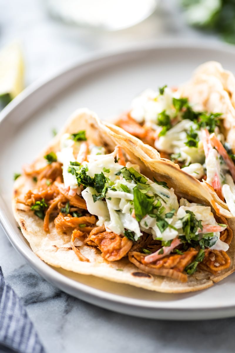 These Slow Cooker BBQ Pulled Pork Tacos served with a cilantro lime coleslaw are easy to make and perfect for healthy weeknight meals! The recipe is gluten free and freezer-friendly.