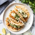 These Slow Cooker BBQ Pulled Pork Tacos served with a cilantro lime coleslaw are easy to make and perfect for healthy weeknight meals! The recipe is gluten free and freezer-friendly.