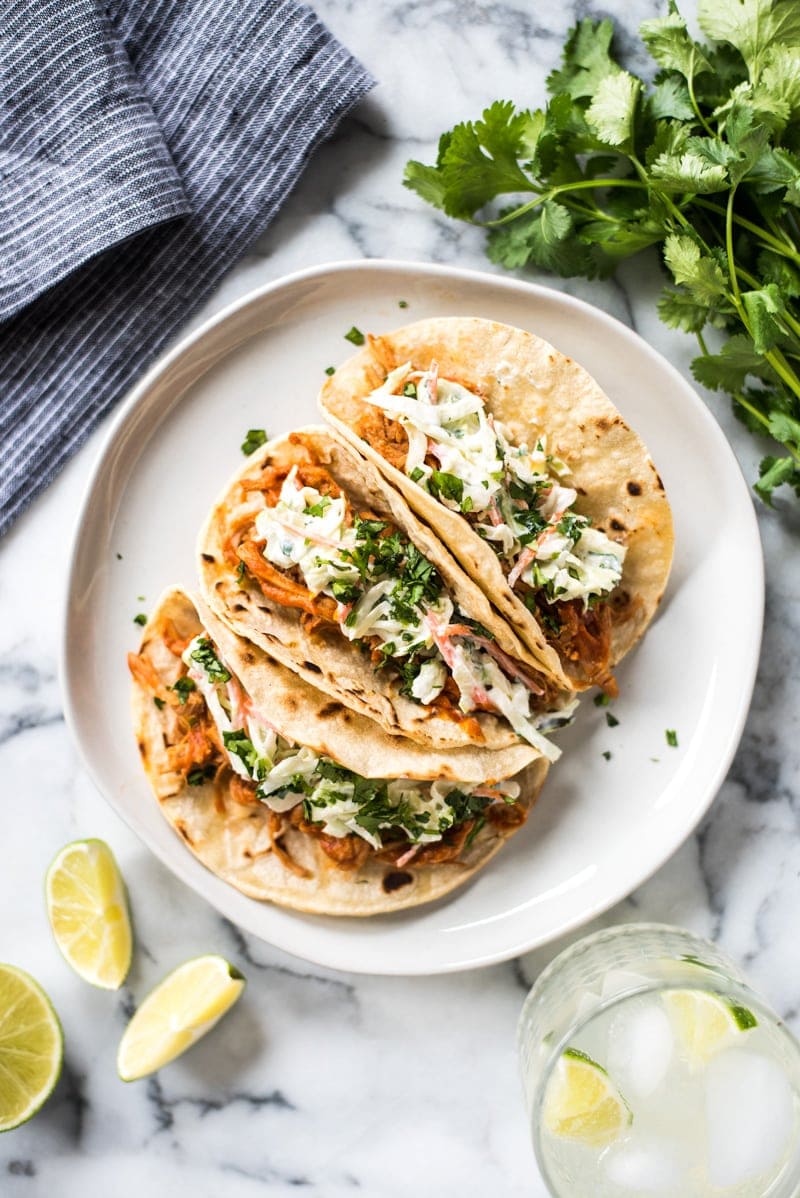 These Slow Cooker BBQ Pulled Pork Tacos served with a cilantro lime coleslaw are easy to make and perfect for healthy weeknight meals! The recipe is gluten free and freezer-friendly.