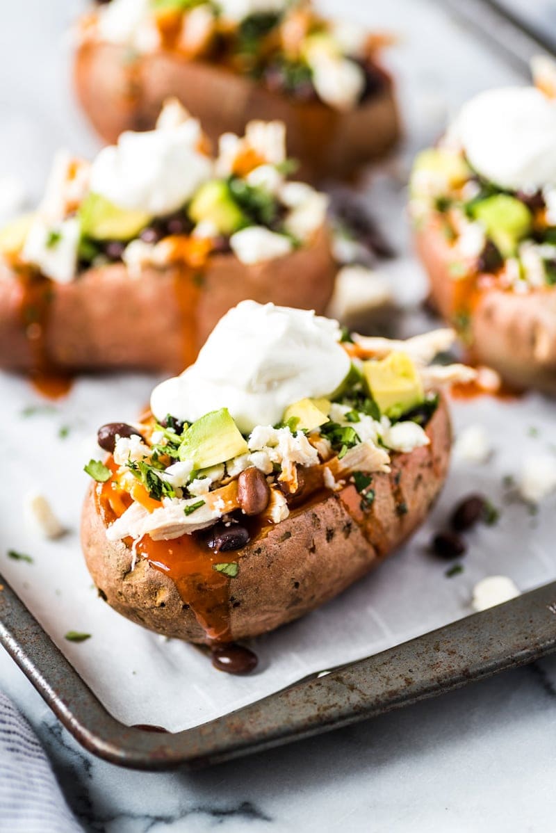 These Chicken Enchilada Stuffed Sweet Potatoes are an easy to make Mexican inspired dinner recipe stuffed with shredded chicken, red enchilada sauce and all your favorite toppings! (gluten free)