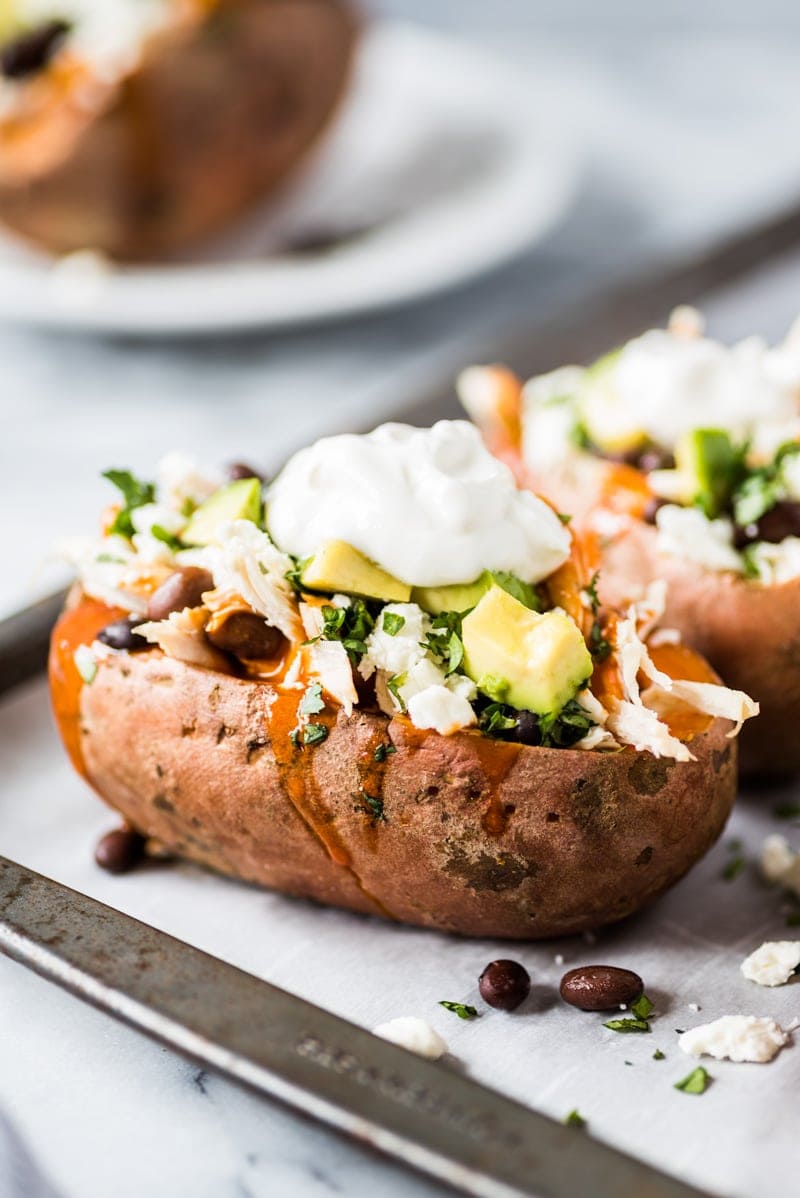These Chicken Enchilada Stuffed Sweet Potatoes are an easy to make Mexican inspired dinner recipe stuffed with shredded chicken, red enchilada sauce and all your favorite toppings! (gluten free)
