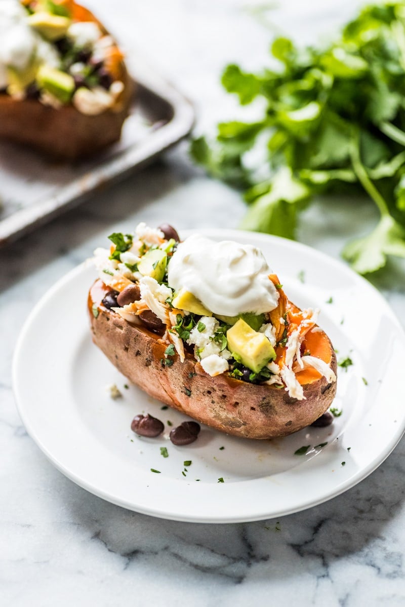 These Chicken Enchilada Stuffed Sweet Potatoes are an easy to make Mexican inspired dinner recipe stuffed with shredded chicken, red enchilada sauce and all your favorite toppings! (gluten free)