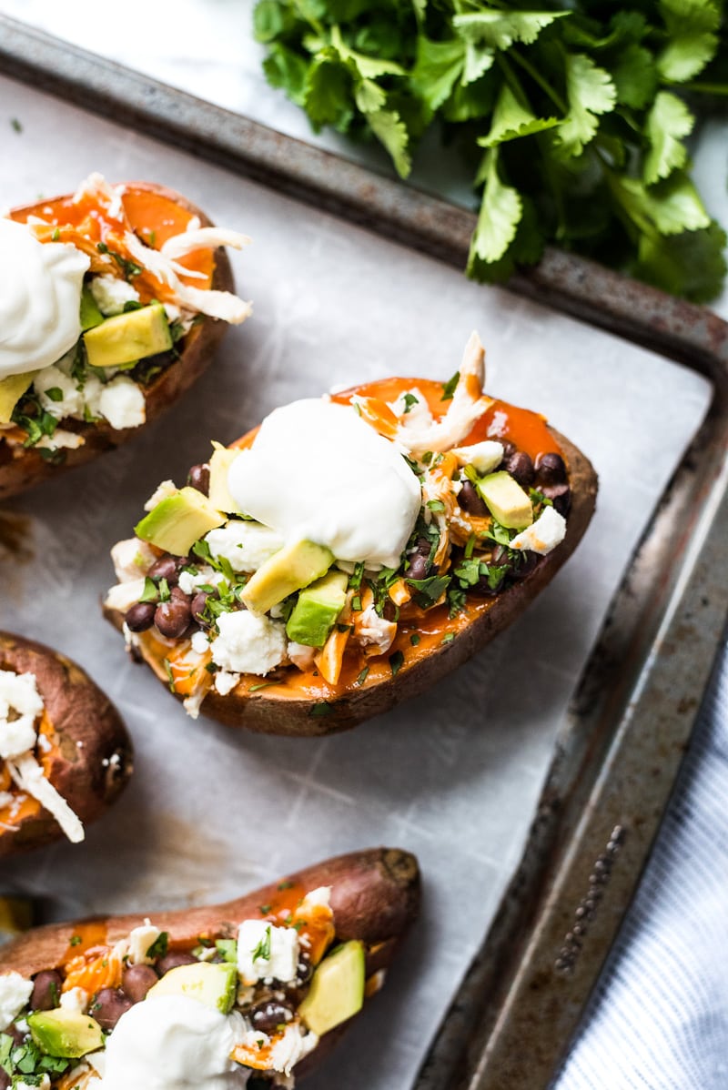 These Chicken Enchilada Stuffed Sweet Potatoes are an easy to make Mexican inspired dinner recipe stuffed with shredded chicken, red enchilada sauce and all your favorite toppings! (gluten free)