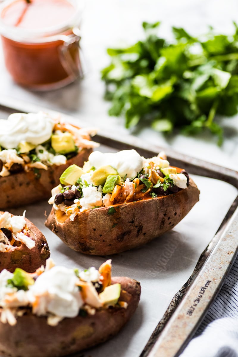 These Chicken Enchilada Stuffed Sweet Potatoes are an easy to make Mexican inspired dinner recipe stuffed with shredded chicken, red enchilada sauce and all your favorite toppings! (gluten free)