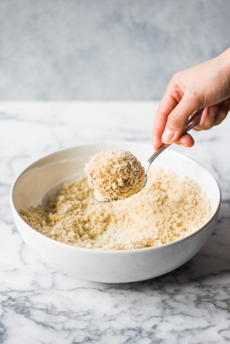 Removing arancini rice balls from panko breadcrumbs.