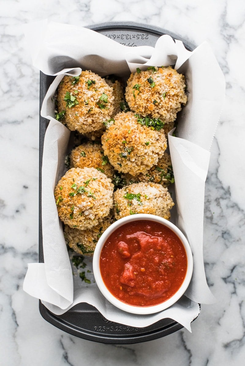 These arancini rice balls are Mexican inspired savory rice balls filled with melted cheese and covered in crispy panko breadcrumbs baked to golden perfection.