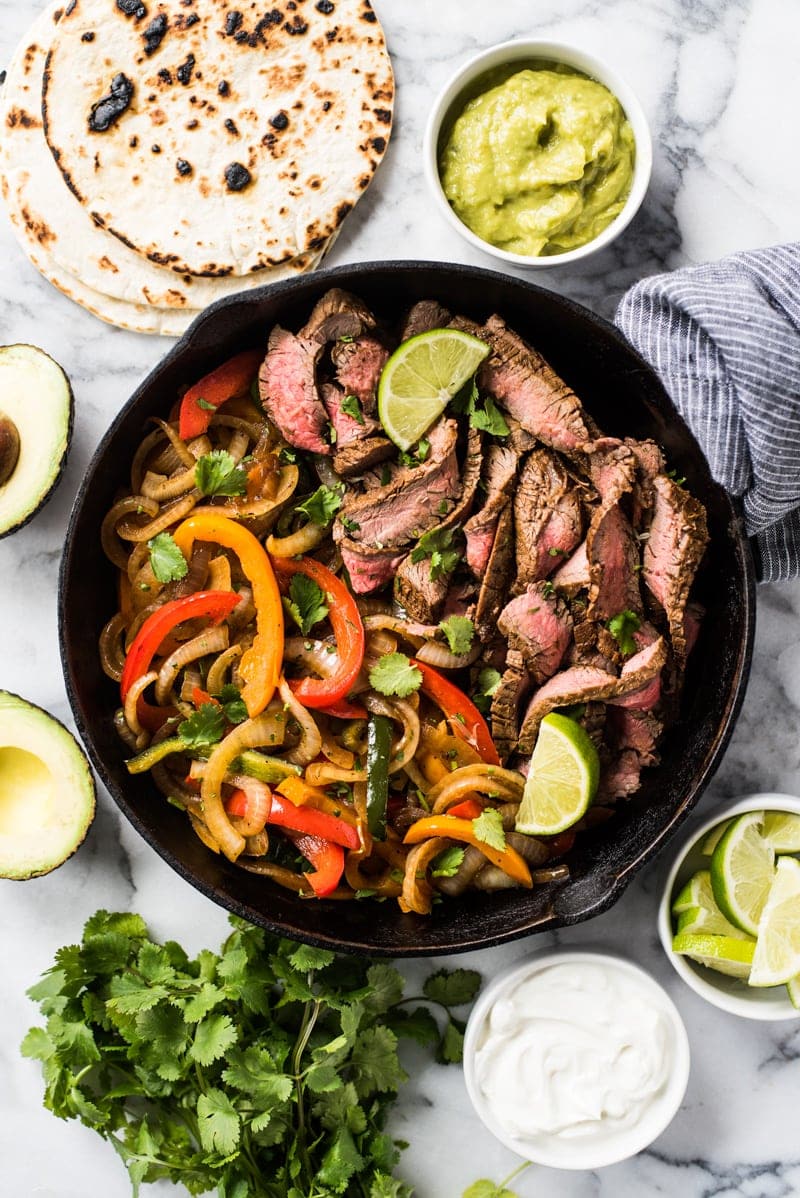 Cooked Steak Fajitas with Onions and Peppers in a Black Cast Iron Pan