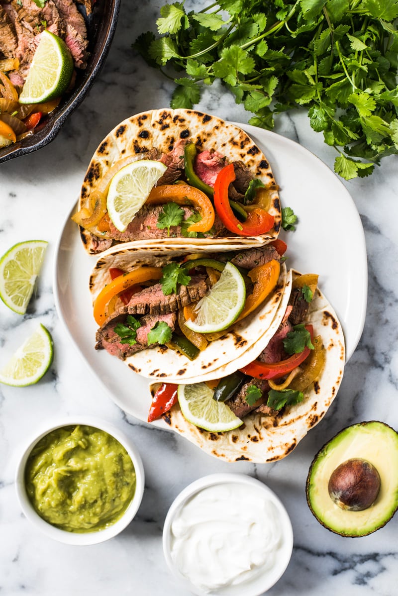 Sliced steak fajitas in warm flour tortillas with peppers and onions.