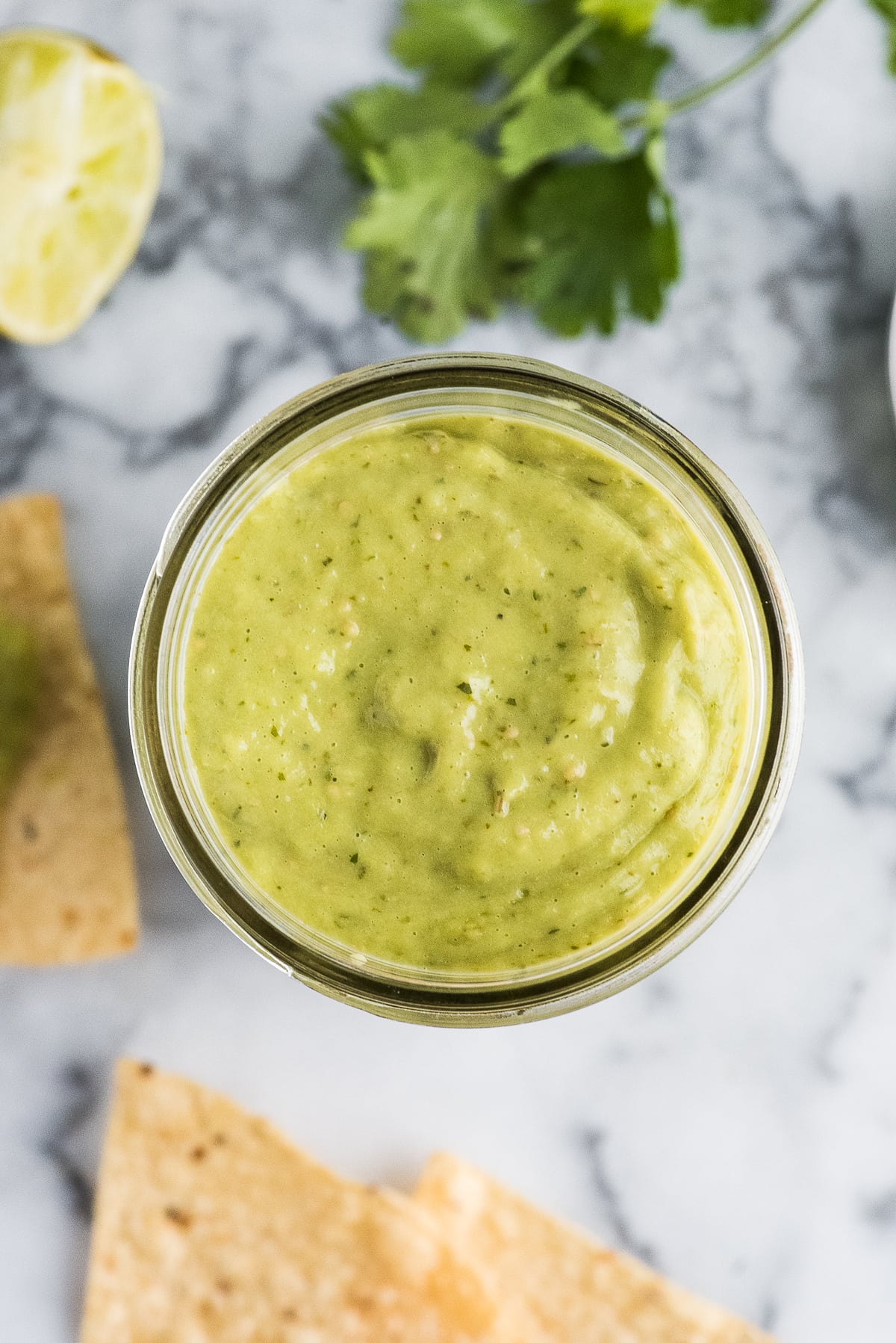 Guacamole salsa in a jar on a table.