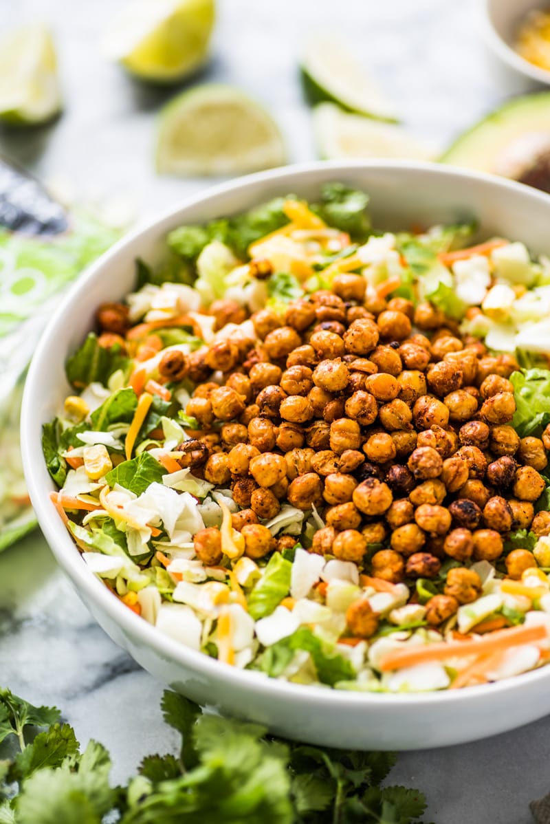 Chopped salad recipe topped with roasted chickpeas and avocado ranch dressing.