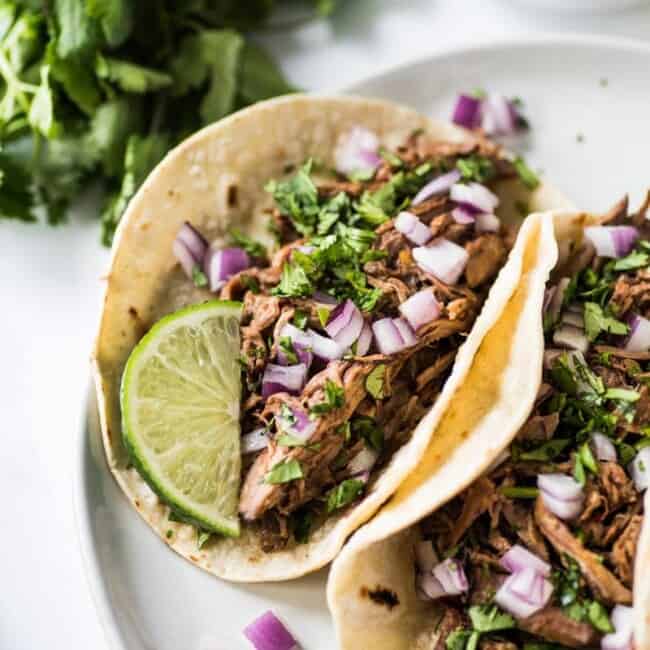 This Mexican Barbacoa Recipe is made in the slow cooker or Instant Pot for easy and flavorful shredded beef that can be served in tacos, salads, burritos and more! (gluten free, low carb, paleo)