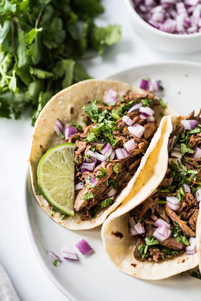 This Mexican Barbacoa Recipe is made in the slow cooker or Instant Pot for easy and flavorful shredded beef that can be served in tacos, salads, burritos and more! (gluten free, low carb, paleo)