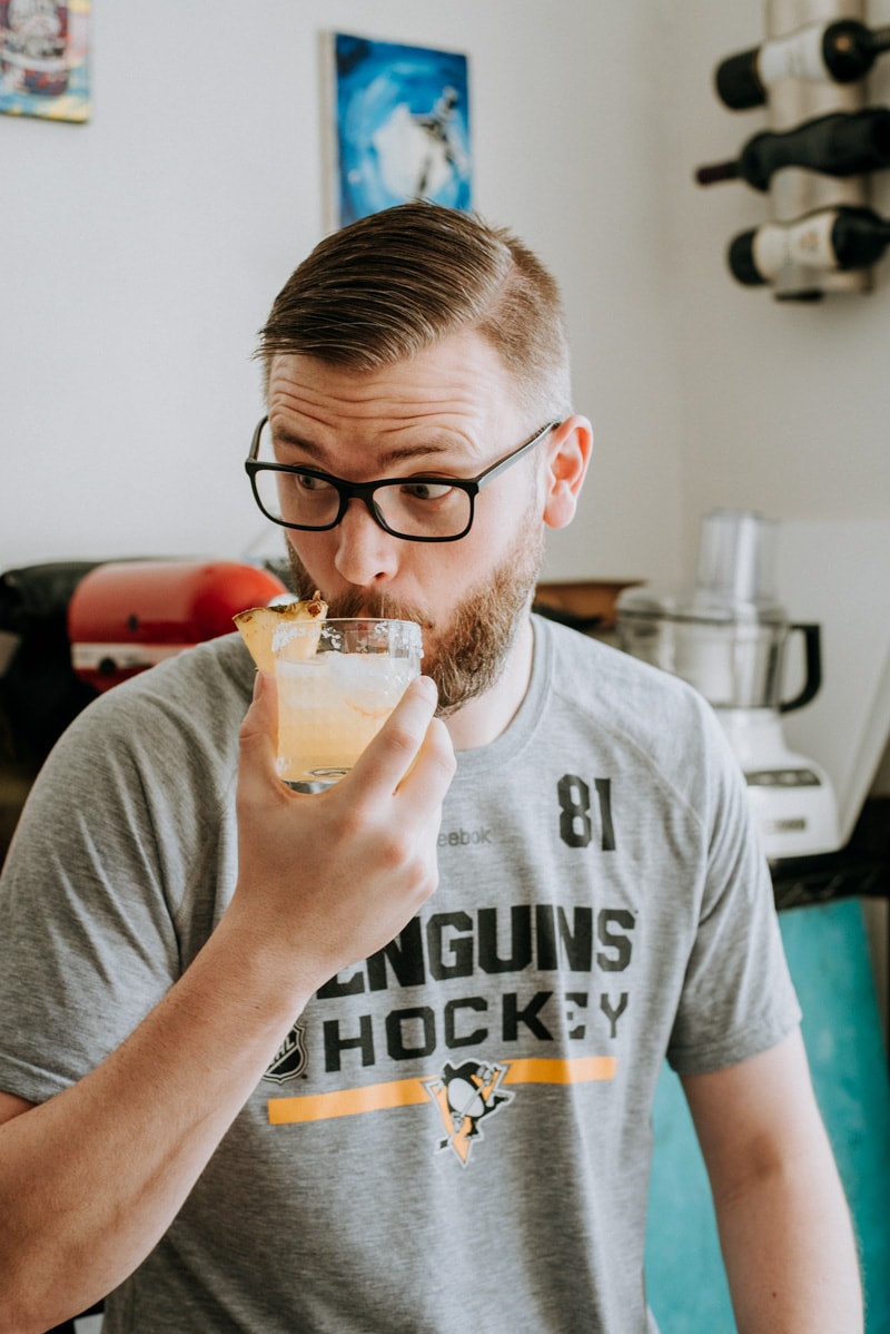 A man enjoying a pineapple margarita. 