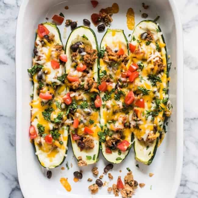 Zucchini Boats are stuffed with chipotle seasoned ground turkey, black beans, cheese and all your favorite toppings. It's the perfect healthy, gluten free and low carb meal for any night of the week!