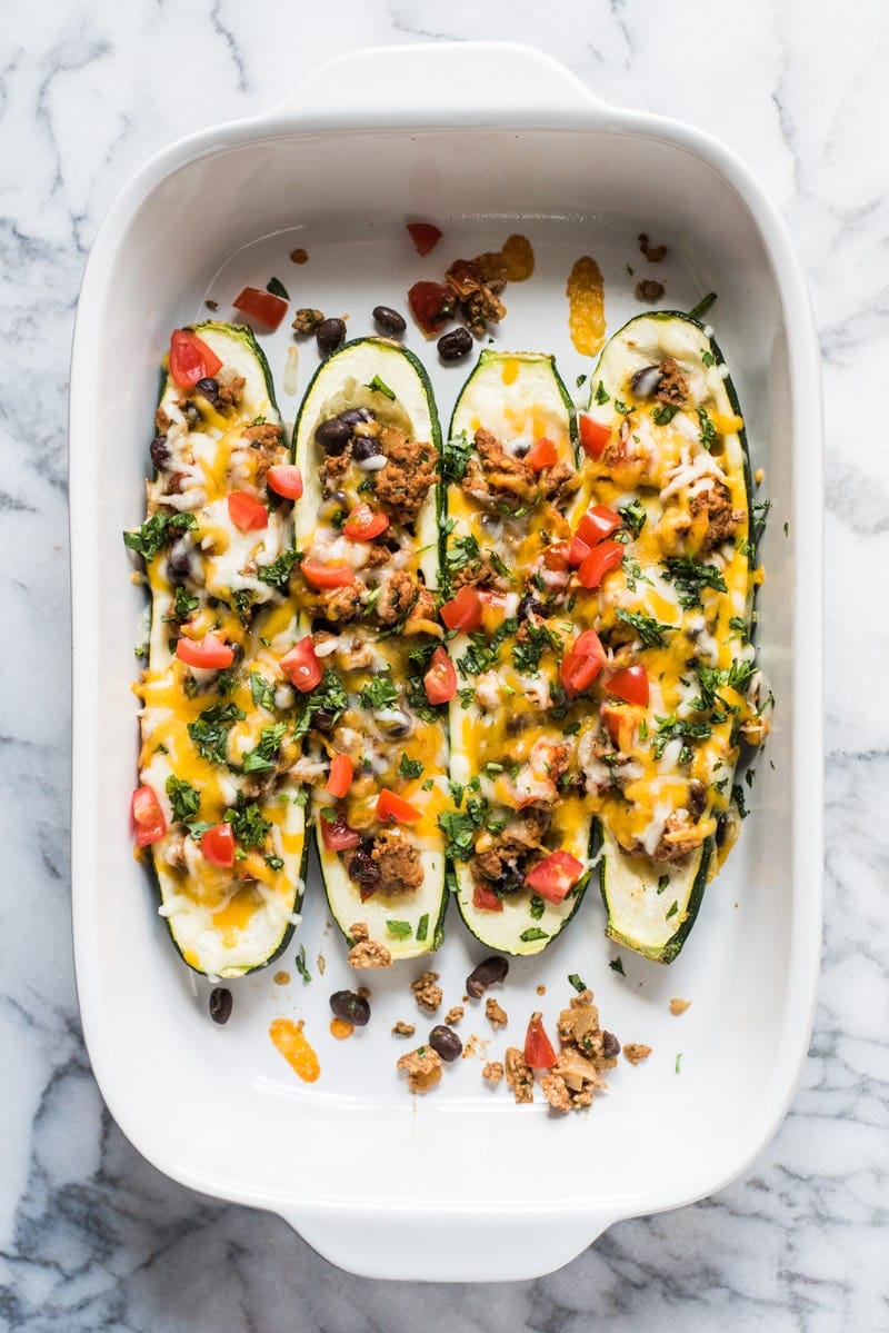 Zucchini boats topped with cheese and cilantro.