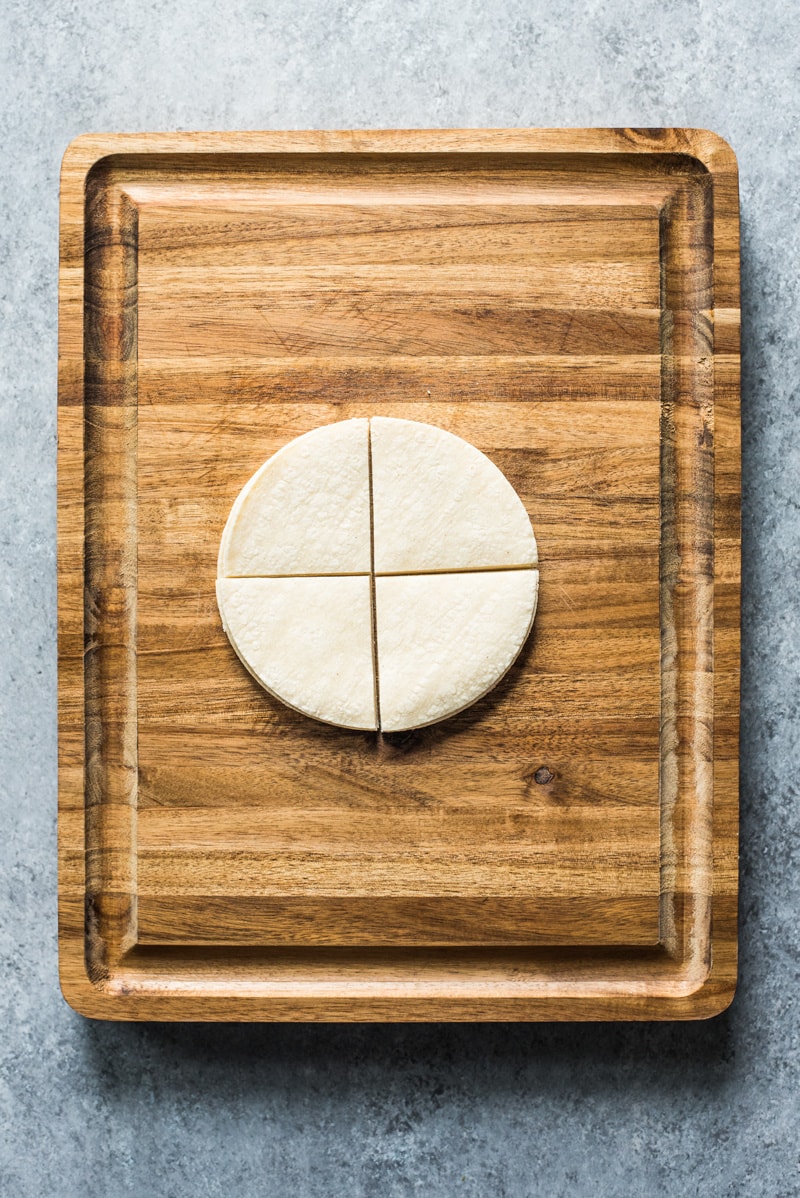 Tortilhas de milho cortadas em quartos para fazer tortilhas caseiras.