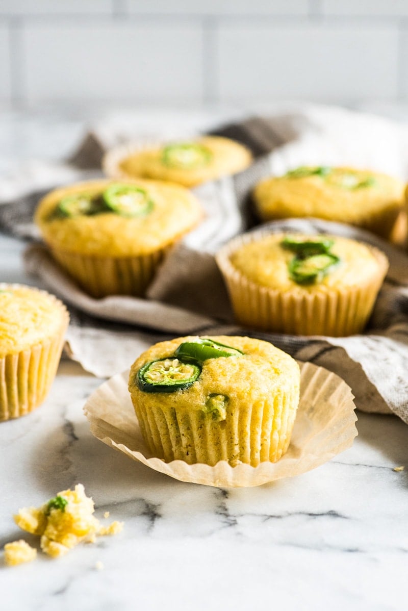Jalapeno cornbread muffins on a white marble table.