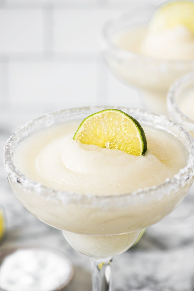 A lime wedge on top of a frozen margarita.