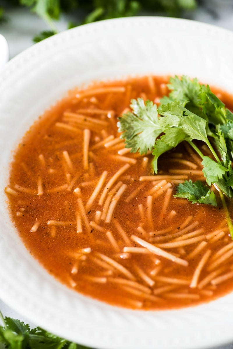 Sopa de fideo in a white bowl topped with cilantro.