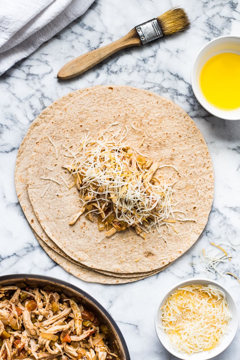 Whole wheat flour tortilla filled with shredded chicken and cheese for chimichangas.
