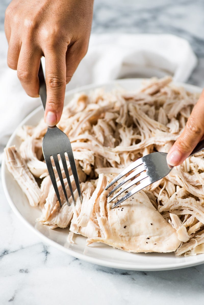 An Easy Shredded Chicken recipe that makes juicy, flavorful and tender chicken every time. Use it in omelets, salads, tacos, nachos, soups, rice bowls, burritos, enchiladas and more!