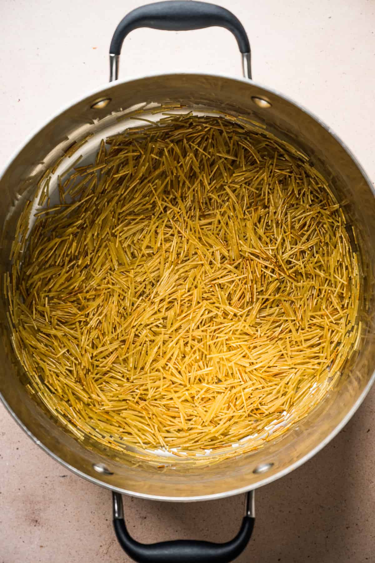 Toasted fideo noodles in a pot.