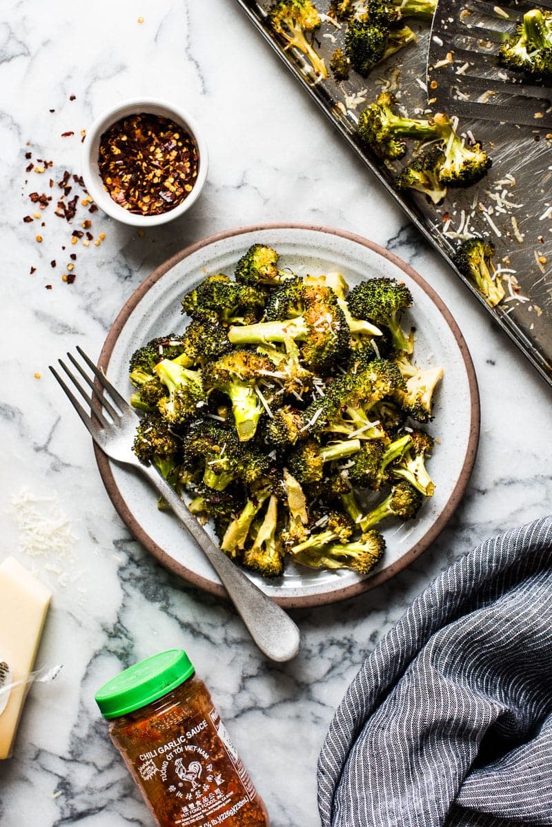 Ready in only 15 minutes, this Roasted Broccoli is tossed in a chili garlic sauce and topped with Parmesan cheese for a healthy and delicious veggie side dish!