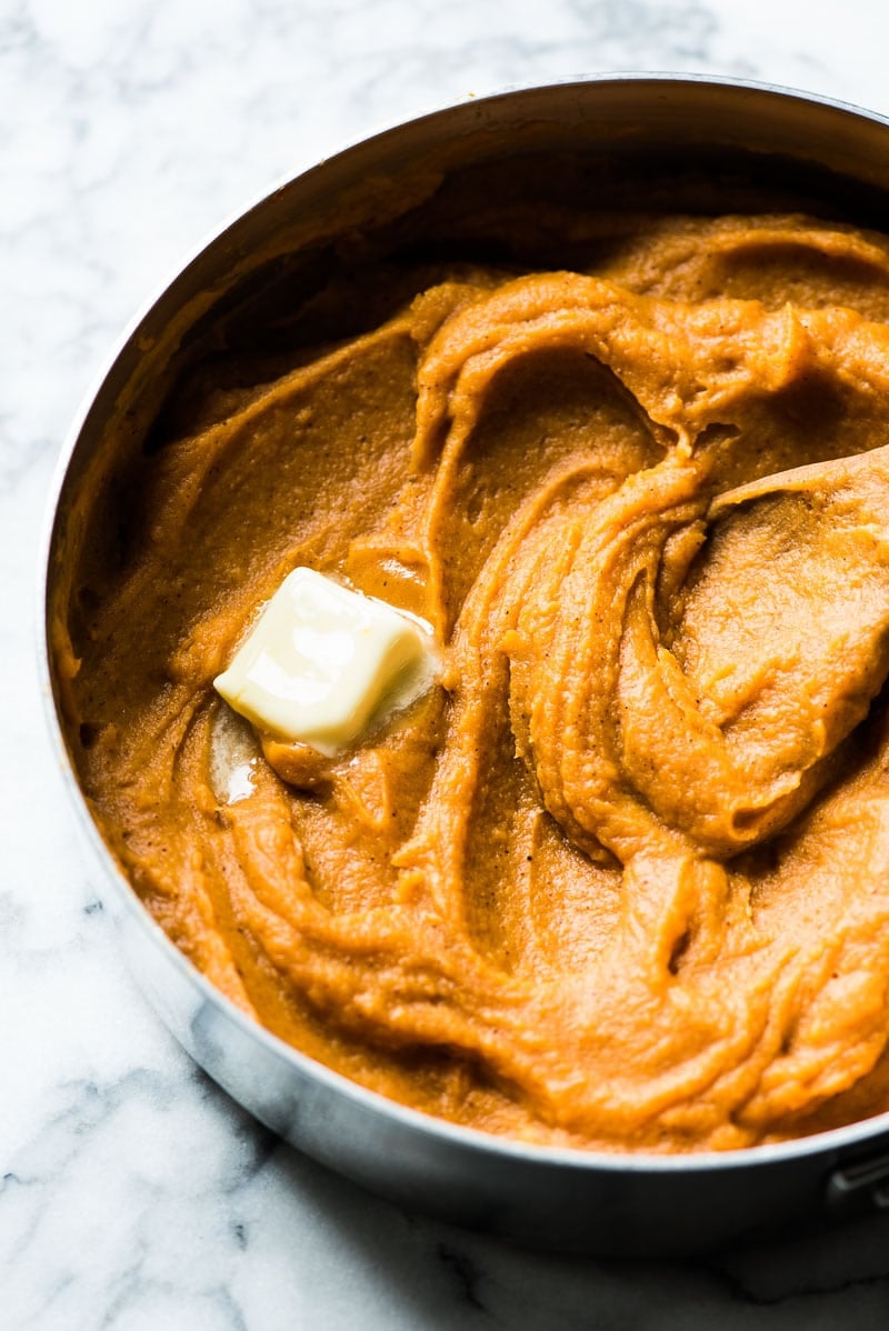 Mashed sweet potatoes topped with butter for a healthy sweet potato casserole.