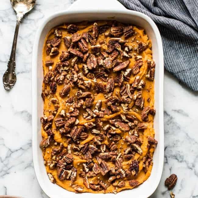 Healthy sweet potato casserole topped with candied pecans.