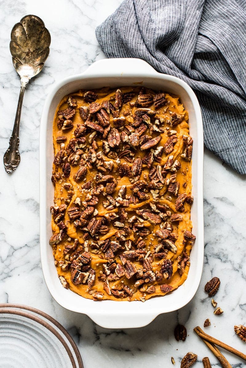 Healthy sweet potato casserole topped with pecans.