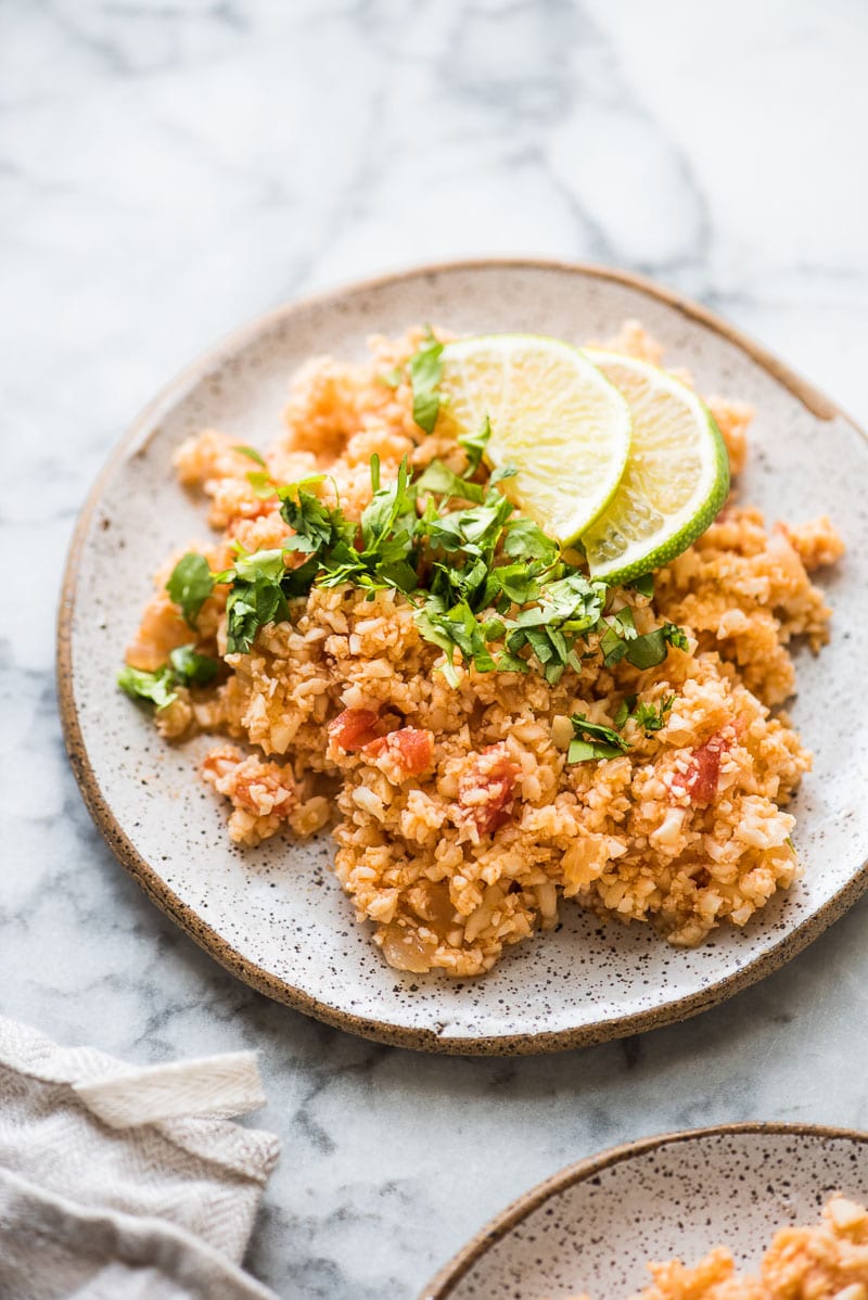 Mexican Cauliflower Rice served on a plate topped with chopped cilantro.