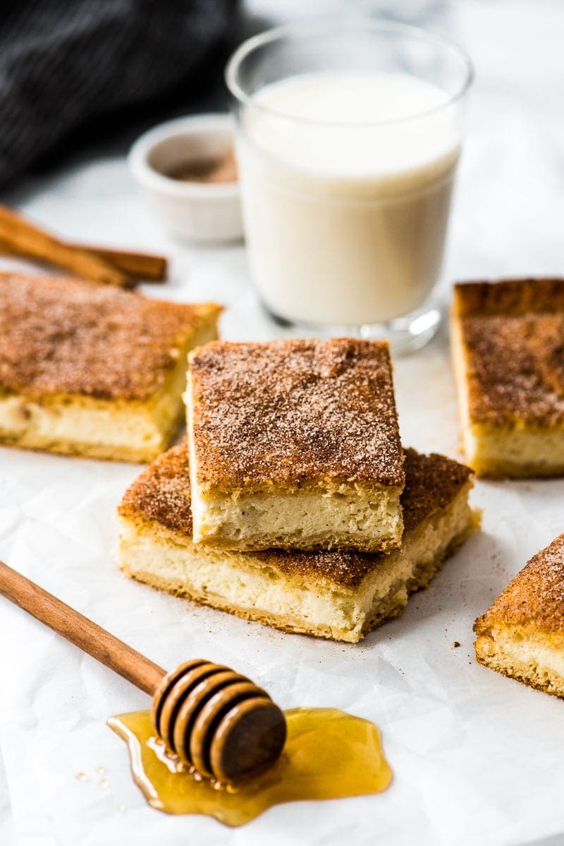 Sopapilla cheesecake on a table next to a glass of milk.