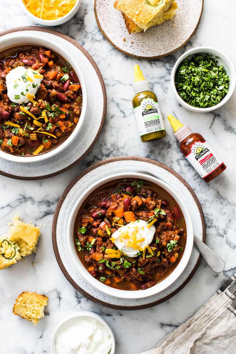 This Spicy Vegetarian Chili is thick, satisfying and super filling! Serve it with your favorite toppings for an easy and healthy meatless meal. (gluten free, vegetarian, vegan) Featuring Yellowbird hot sauce and jalapeno cornbread.