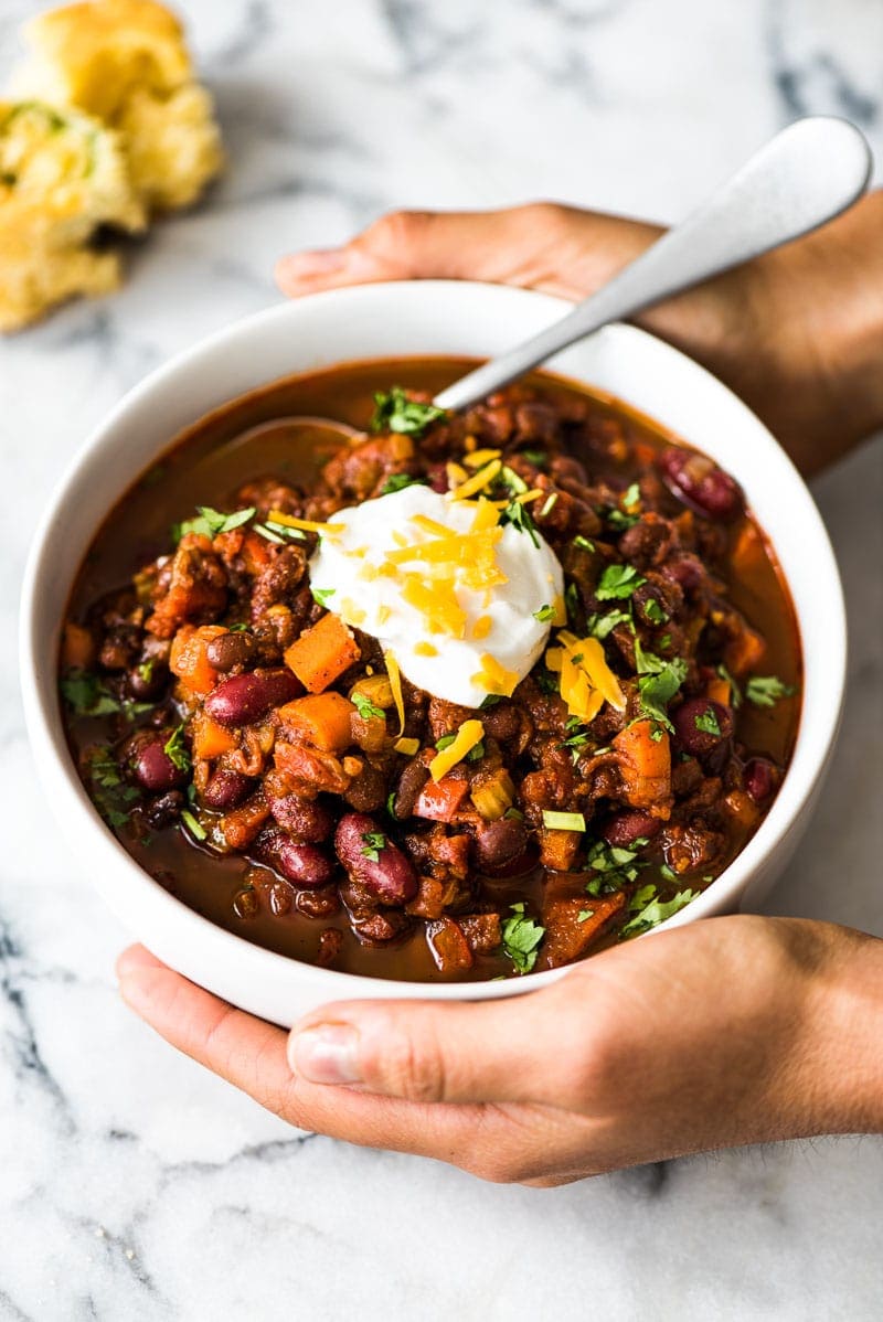 A bowl of chili topped with cheese and sour cream.