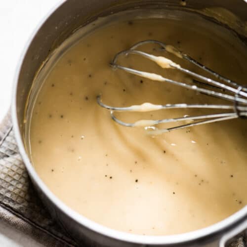 Turkey gravy from drippings in a saucepan with a whisk.