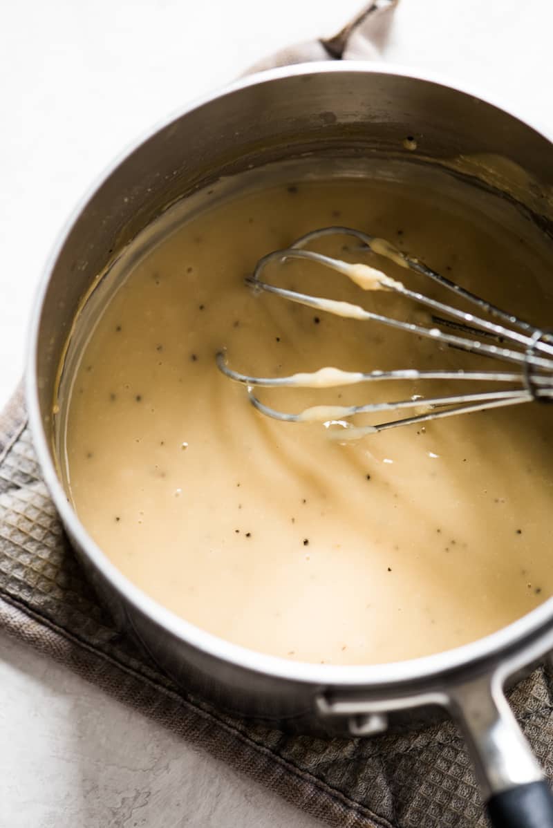Turkey gravy from pan drippings in a saucepan with a whisk.