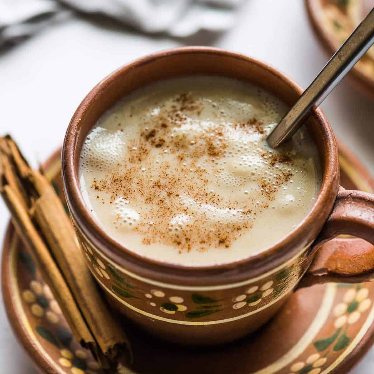 Mexican atole in a mug sprinkled with ground cinnamon.