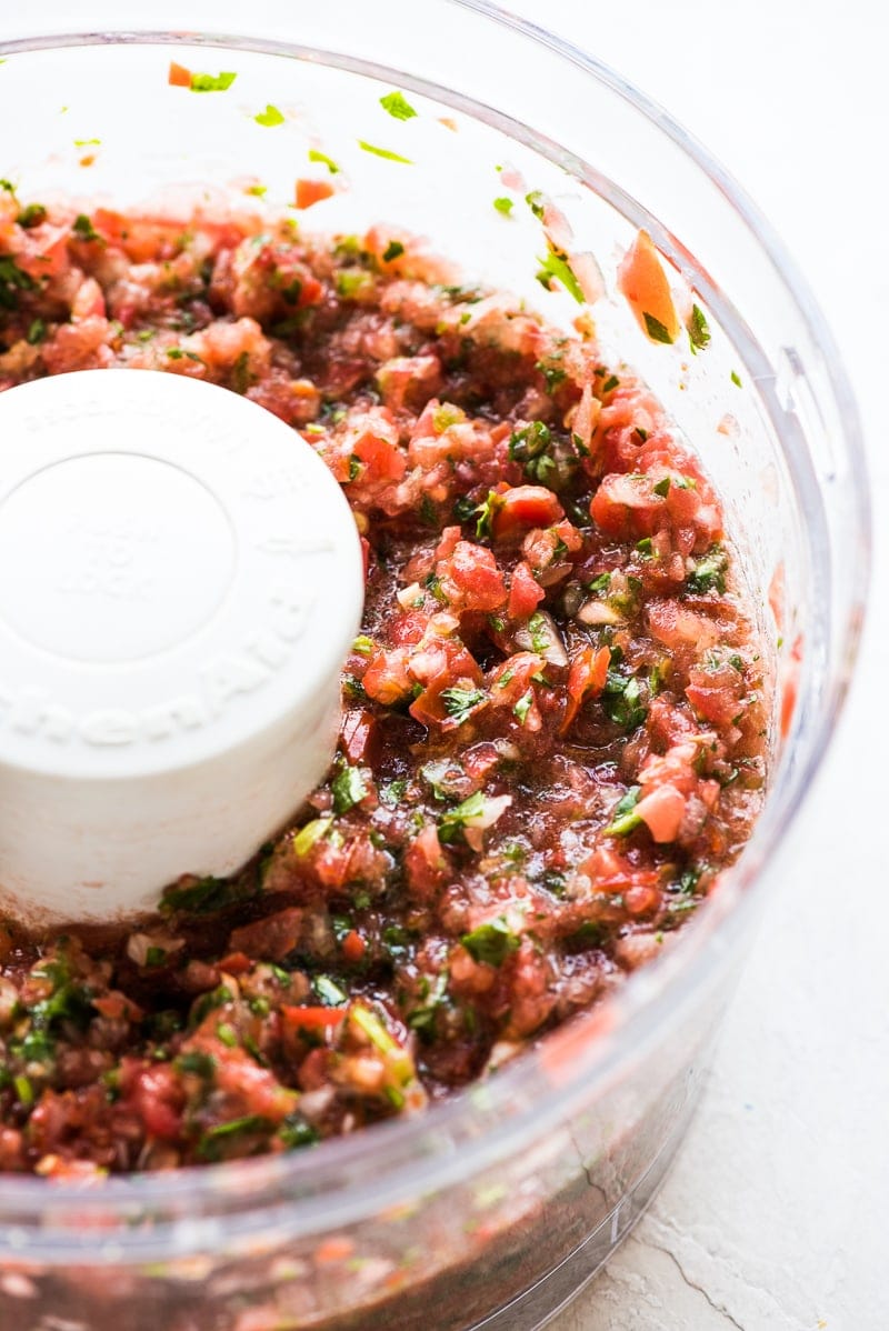 Homemade fresh salsa made from tomatoes, onions and cilantro in a food processor.