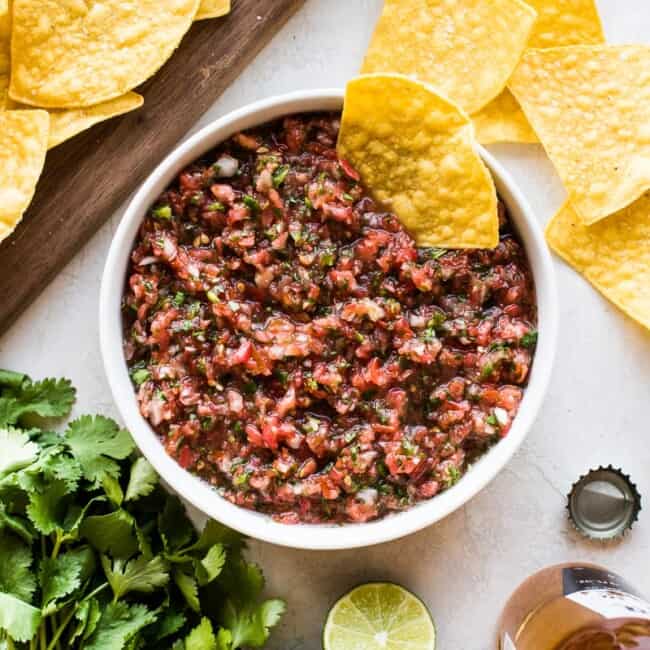 Fresh salsa recipe in a bowl ready to be eaten with tortilla chips.