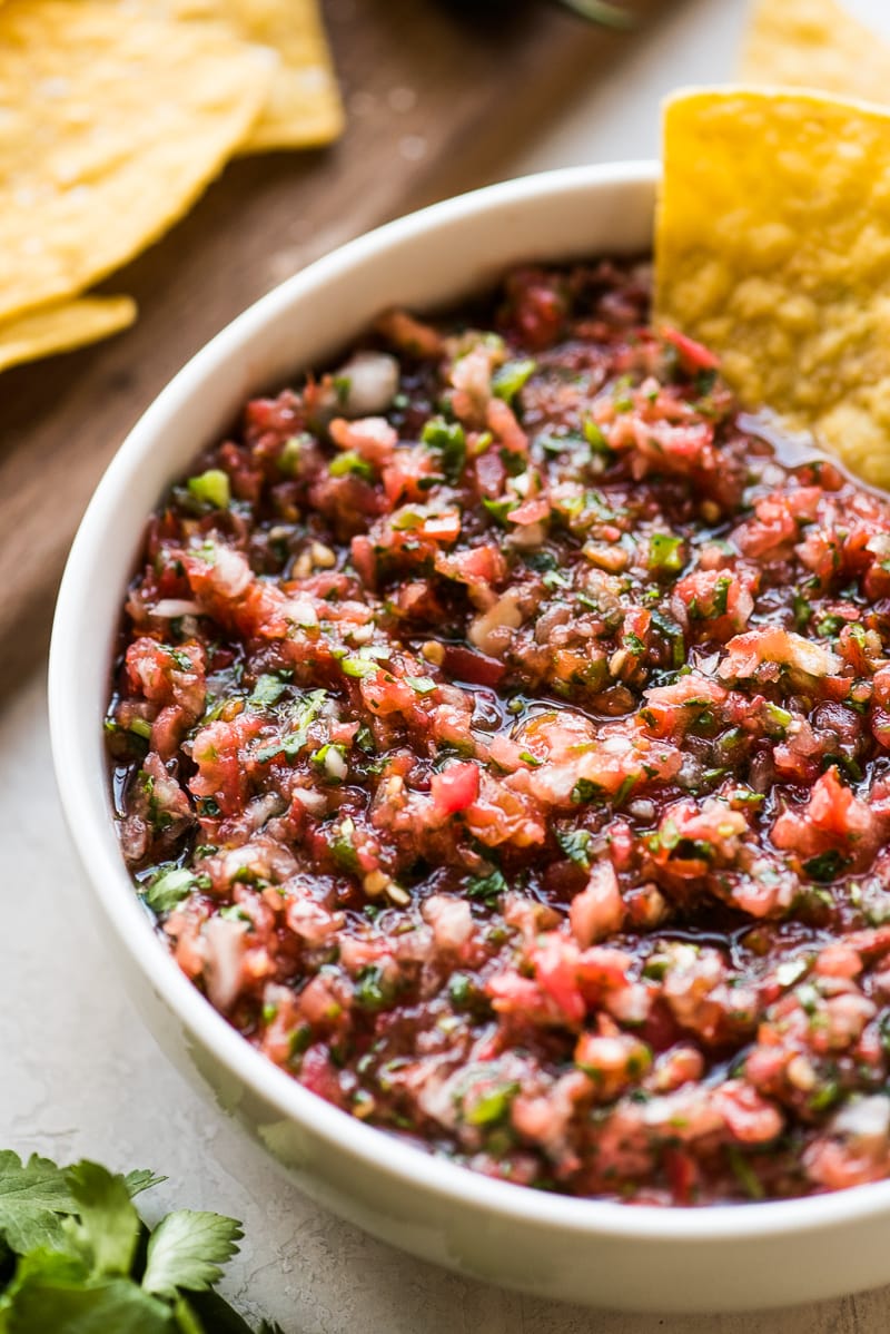 Fresh salsa recipe in a white bowl served with tortilla chips.