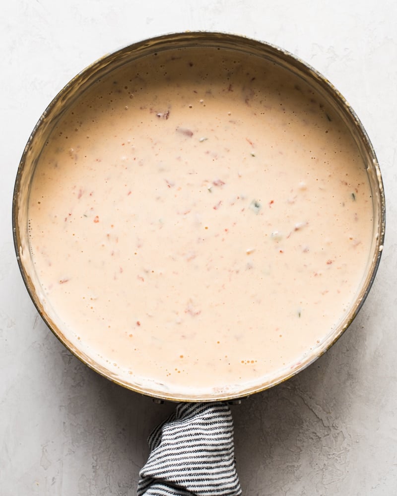 Large saute pan with melted mexican queso dip.