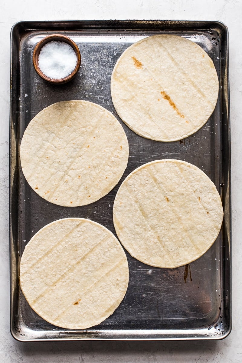 These Homemade Tostadas Shells are baked and ready in only 15 minutes! Top them with refried beans and cheese for a delicious Mexican weeknight meal.