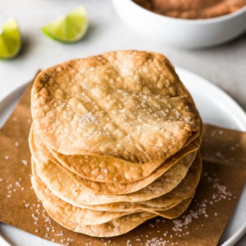 These Homemade Tostadas Shells are baked and ready in only 15 minutes! Top them with refried beans and cheese for a delicious Mexican weeknight meal.