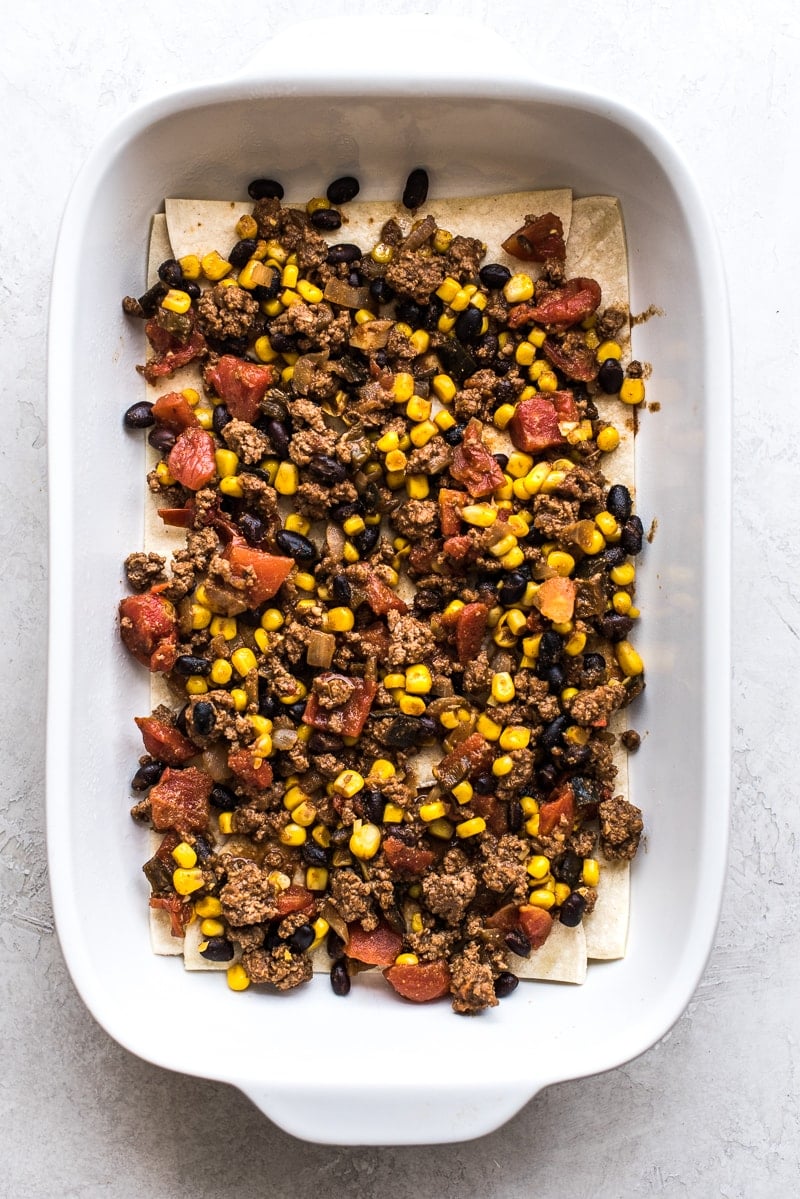 This Easy Taco Casserole (also known as Taco Lasagna) is made with 3 layers of corn tortillas, ground beef, corn, black beans, the best taco seasoning and lots of melted cheese!