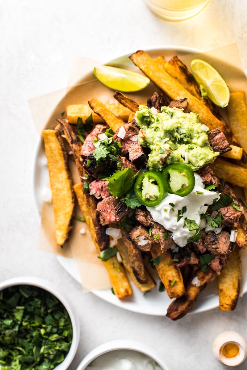 Carne asada fries topped with guacamole and sour cream.